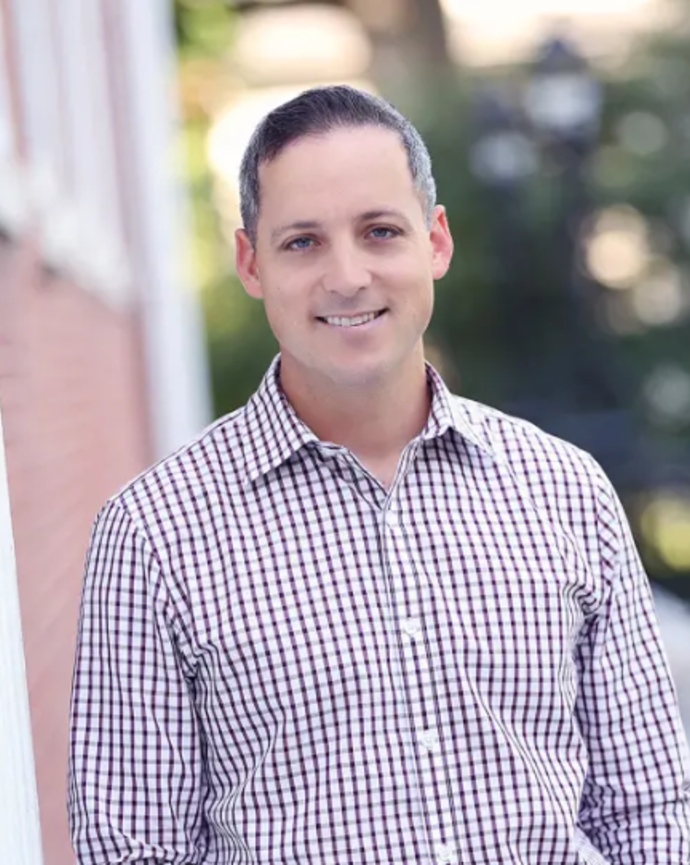 headshot of Phil Capin standing in front of a Harvard building